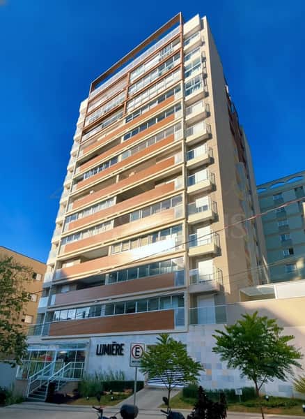 Fachada de edifício residencial moderno. Destaque para varandas com revestimento amadeirado e janelas amplas.