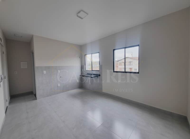 Sala clara com piso cinza, pia e duas janelas com vista para a rua. Ambiente clean e moderno.