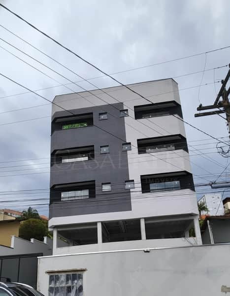 Fachada moderna de prédio com design em tons de cinza e branco. Destaque para as janelas horizontais.