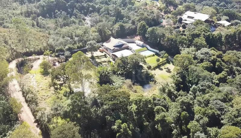 Casa luxuosa com piscina em área verde exuberante. Arquitetura moderna, perfeita integração com a natureza.